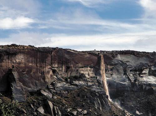 A spontaneous waterfall, 300 feet tall, forms after a cloud burst south of Bluff.   Josh Ewing photo